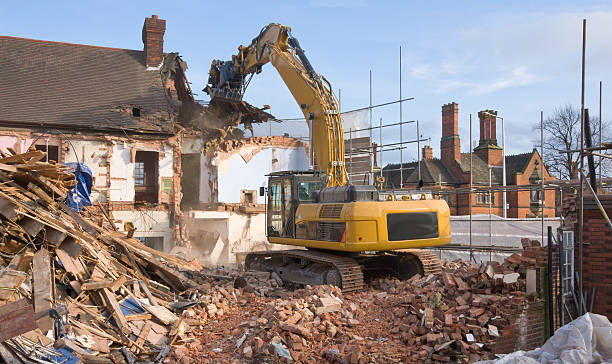 Demolishing Old Buildings. "A large tracked excavator machine fitted with a demolition tool, ripping apart old houses and buildings in a town centre for re-development." demolished stock pictures, royalty-free photos & images