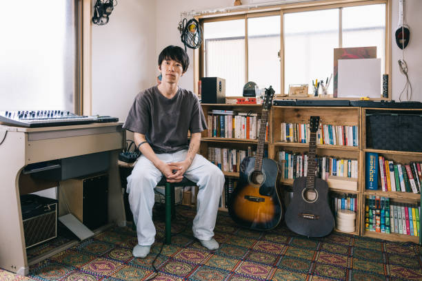自宅のスタジオコーナーにある若い日本人ミュージシャンの肖像画 - lyricist ストックフォトと画像