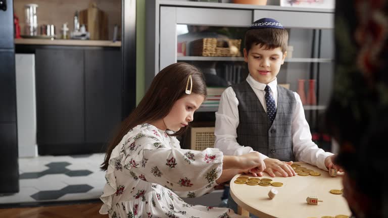 Little girl playing Dreidel with her family