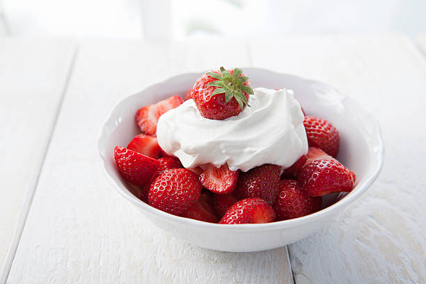Strawberries with whipped cream Strawberries with whipped cream in a small bowl whipped food stock pictures, royalty-free photos & images
