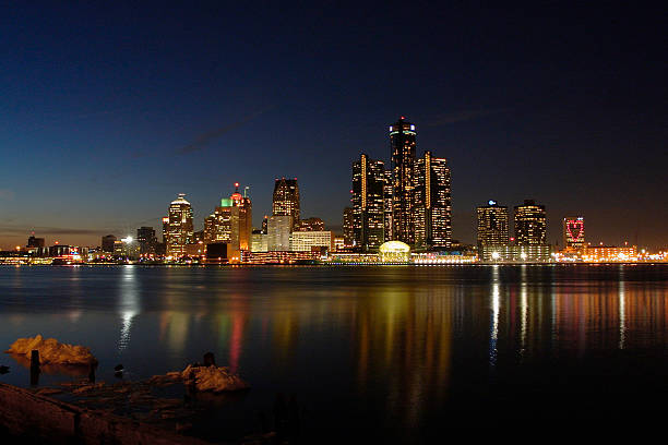 A cityscape of Detroit reflected on a lake "Detroit skyline at night. Viewed from Windsor, Ontario on Valentine's Day." cobo hall photos stock pictures, royalty-free photos & images