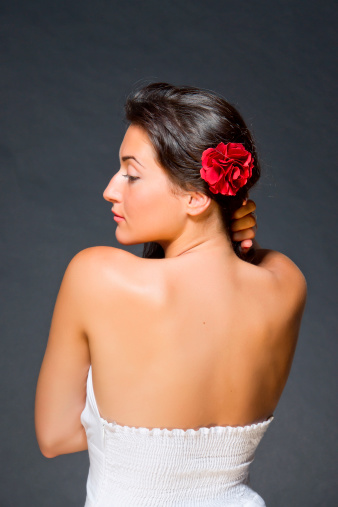 Portrait of young dark haired beautiful woman. Gypsy or spanish style. Back view