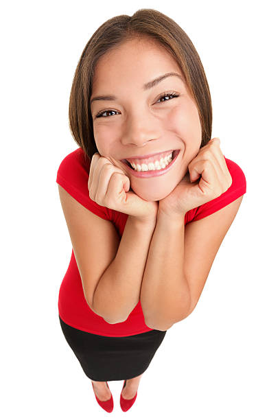 Funny cute excited woman isolated in full length. High angle fish eye like view of young female model in red top isolated on white background. For more: