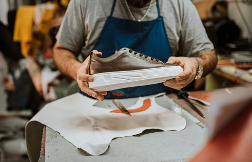 Mature man making shoes in his workshop