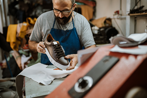 Mature Cobbler admiring to his product