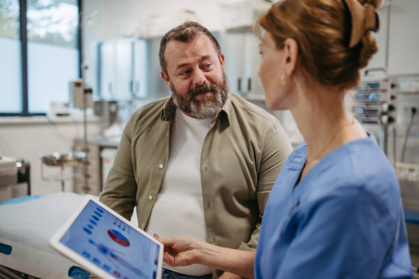 Female doctor consulting with the overweight patient, discussing test result in doctor office. Obesity affecting middle-aged men's health. Concept of health risks of overwight and obesity. doctora que consulta con paciente con sobrepeso, discutiendo el resultado de la prueba en el consultorio del médico. la obesidad afecta la salud de los hombres de mediana edad. concepto de riesgos para la salud del exceso de peso y la obesidad.
