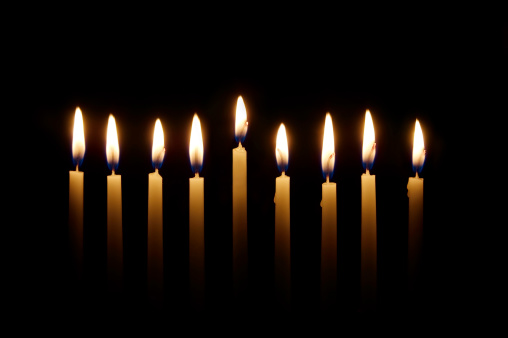 Glowing candles lit for the eighth night of Hanukkah