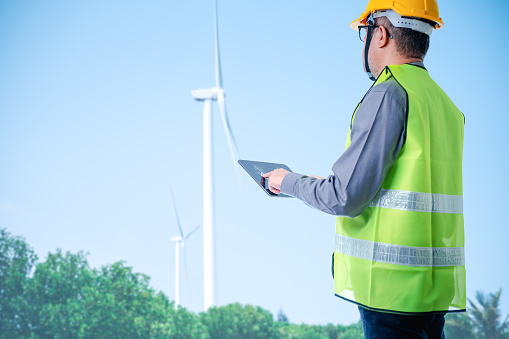 Skilled engineer harnesses power of renewable energy by sustainable, alternative sources such as wind turbines, making positive impact on industrial sector, reducing traditional electricity generators
