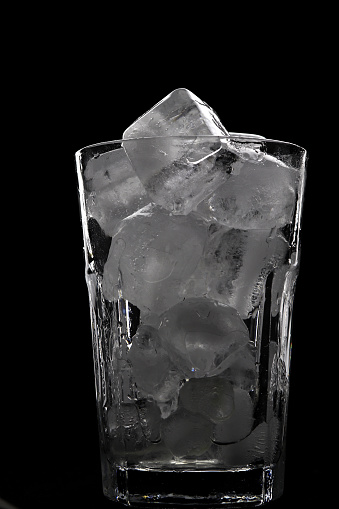 Transparent glass filled with cold ice cubes