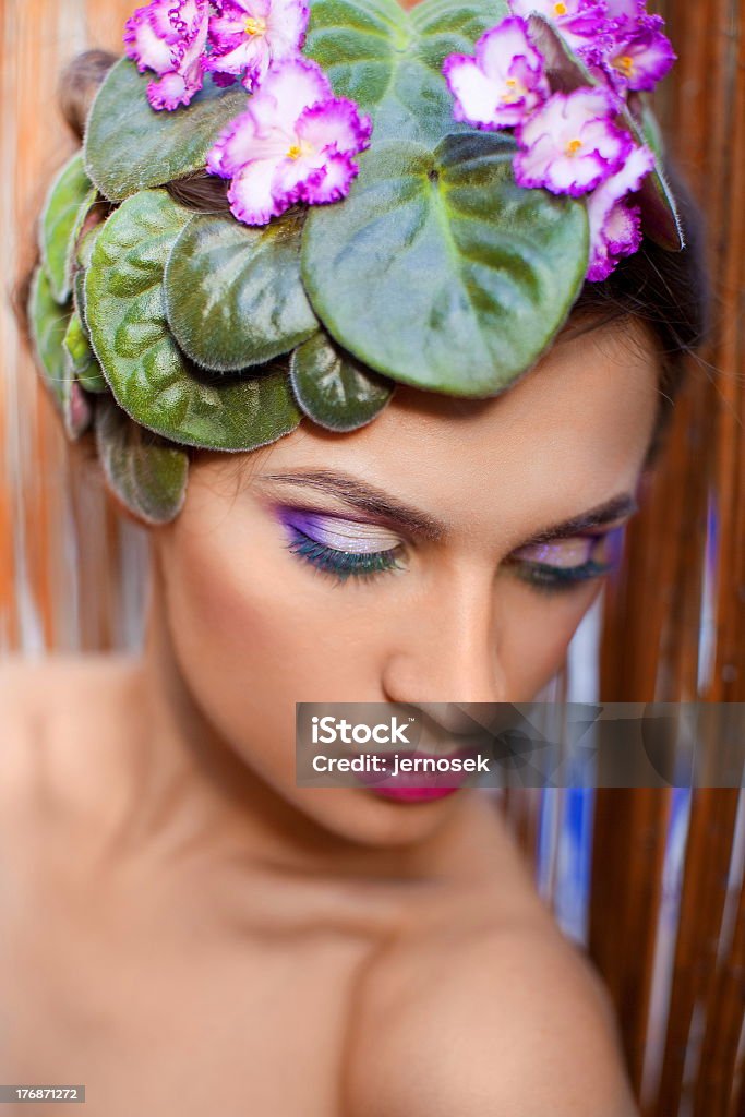 the girl with violets portrait of a beautiful woman hairdo decorated with violets Adult Stock Photo