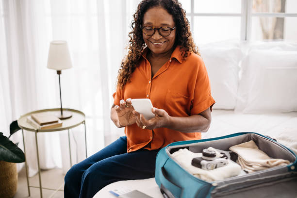 istock Senior woman using the checklist on her phone to pack travel essentials 1768715438