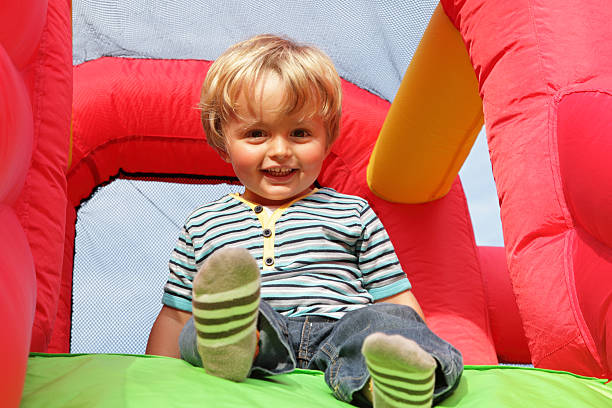 criança em insuflável castelo insuflável - inflatable child jumping leisure games imagens e fotografias de stock