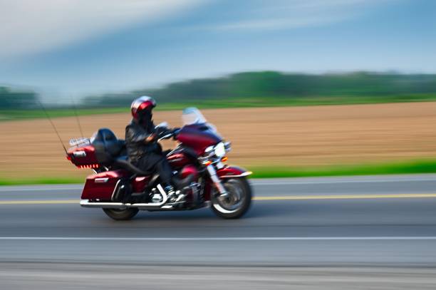 Biker riding motorcycle on mountain road.