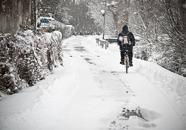 Covered in snow rural street in a winter snowy day with ordinary unrecognizable passing outlier going to work.