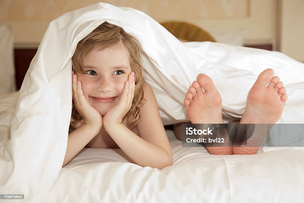 under cover little girl and leg of mother under cover Bed - Furniture Stock Photo