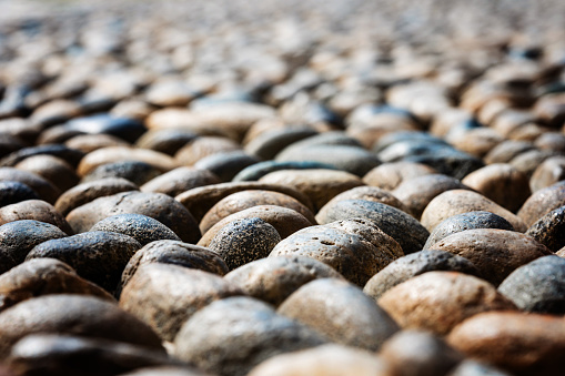 Cobble stones round shaped, old road paved with stones, cobblestone pavement, close up view