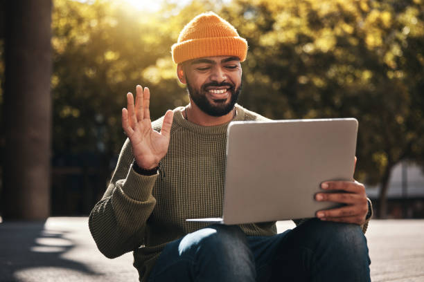 istock Student, laptop and video call outdoor for university, college and online education, e learning or scholarship interview on campus. African man with computer, waves hello and virtual class in a park 1768753834