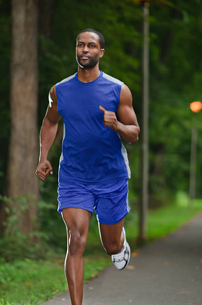 istock Man jogging on path in green park 176875544