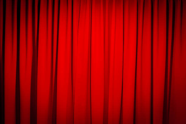 istock Red closed curtain with a light spot 1768759688
