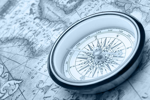 Old compass on ancient map stock photo