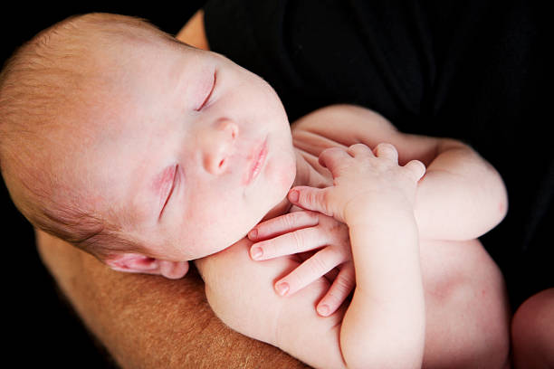 istock Newborn Baby Sleeping with Arms Crossed Over Chest 176876530
