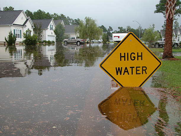 High Water Sign in Flooded Neighborhood Neighborhood flooded. Sign warns of high water. truck in rain stock pictures, royalty-free photos & images