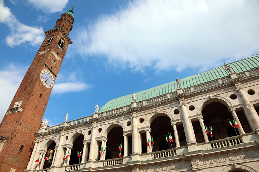 Vicenza, VI, Italy - June 1, 2020:  Monument called BASILICA PALLADIANA and the copper roof with italian flags