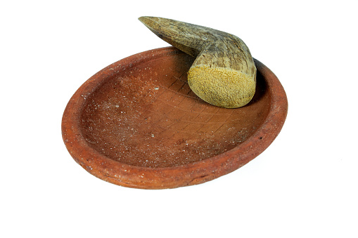 Traditional mortar and pestle made of clay and wood on a white background