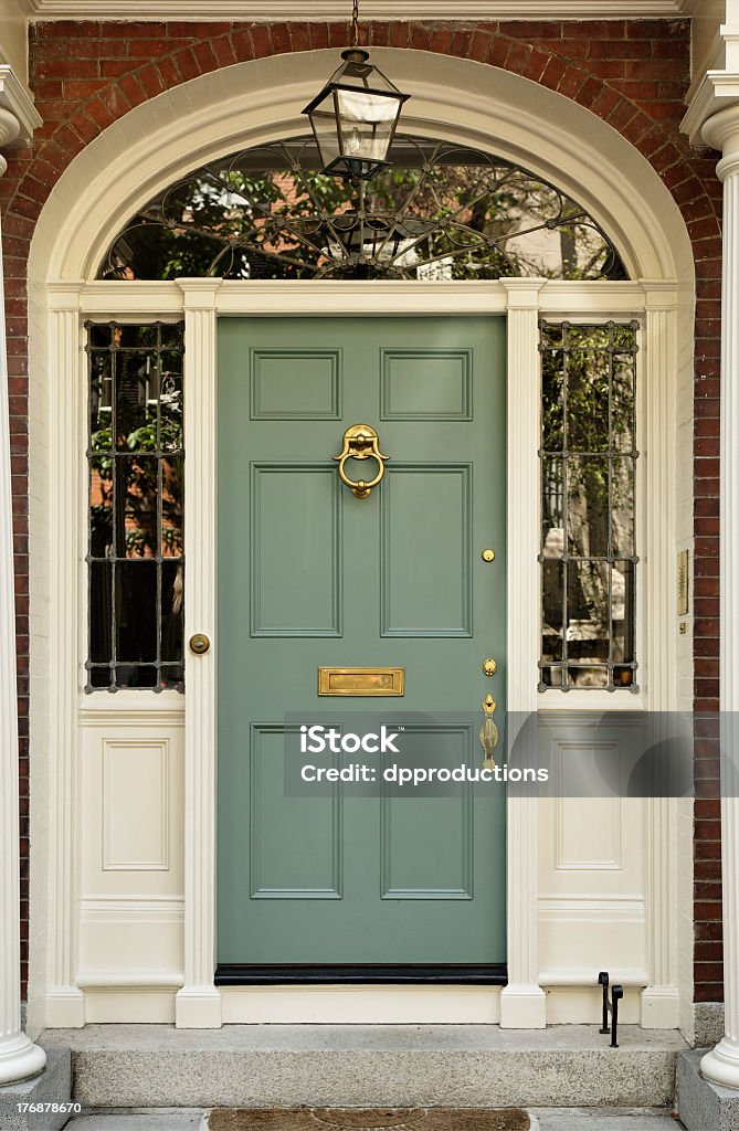 Upscale Home Front Door Front entrance to a home with classic design. The door has a large brass knocker and an elegant frame. Vertical shot. Architectural Feature Stock Photo