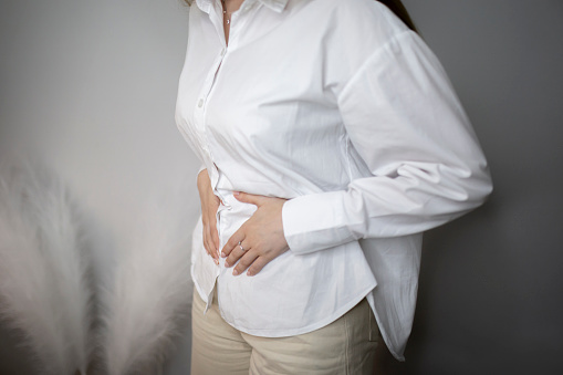 woman holding her stomach and feeling awful stomach ache