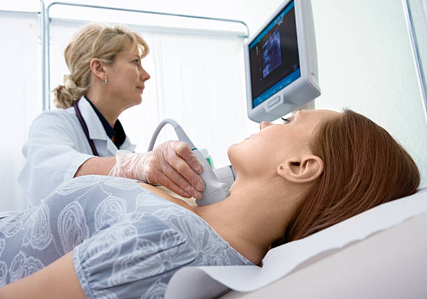 Scanning of a thyroid woman getting ultrasound of a thyroid from doctorPlease see similar images here: diagnostic aid stock pictures, royalty-free photos & images