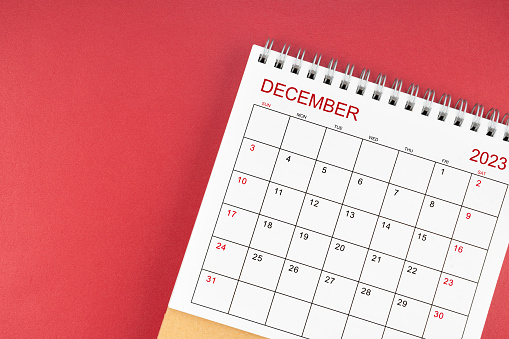 December 2023 desk calendar on red color background.