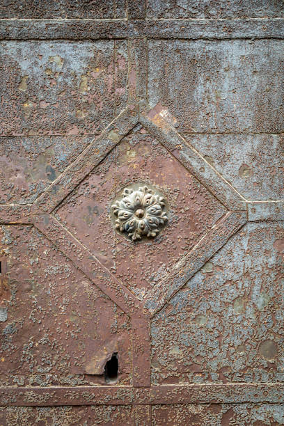 istock An old rusty, holey old door with ornate detailing and peeling paint. 1768796573