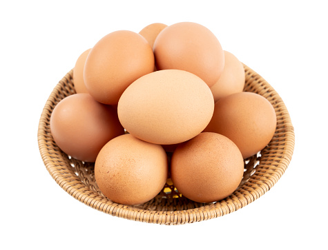 Eggs in wooden basket isolated on white background