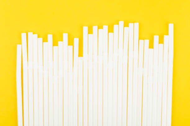 white drinking straws on yellow background. - drinking straw plastic design in a row imagens e fotografias de stock