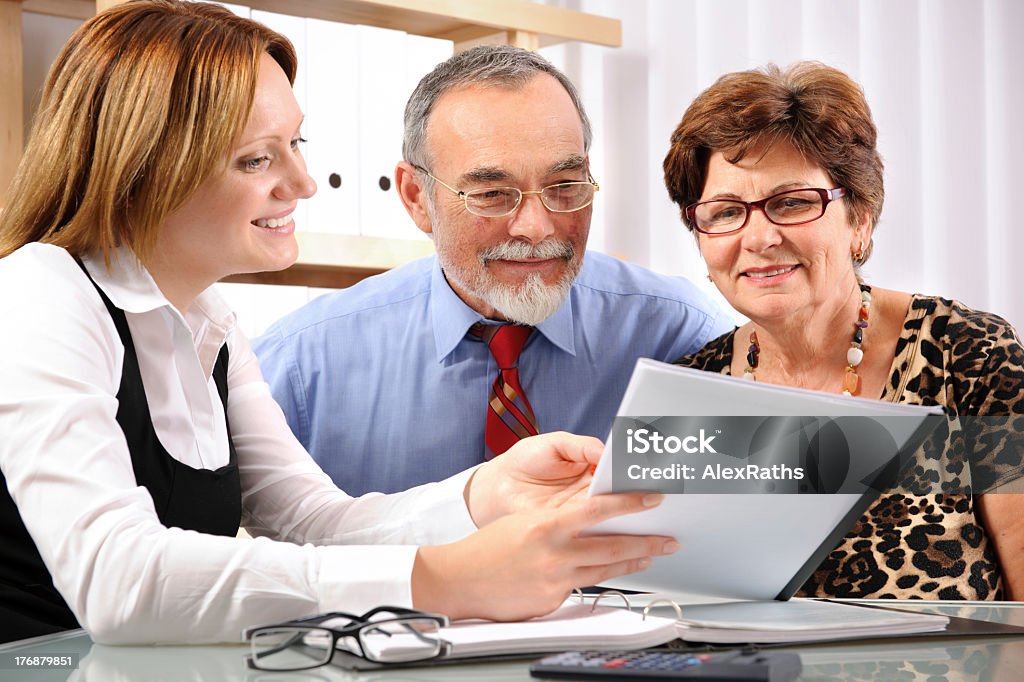 Group of three individuals having a business meeting Senior couple meeting with agent or advisor. Active Seniors Stock Photo