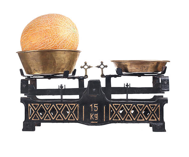 istock Old-fashioned balance scale with melon isolated on white background 176879936