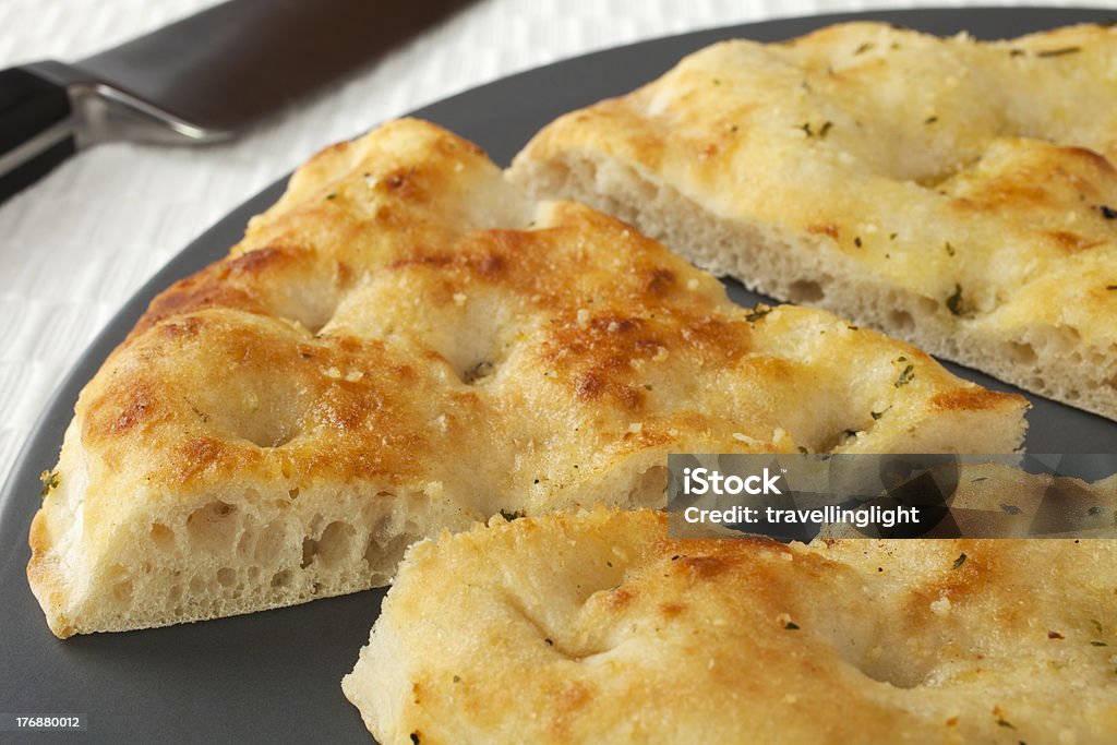 Pizza Bread "Pizza bread with garlic and herbs, on a platter with one slice cut." Bread Stock Photo