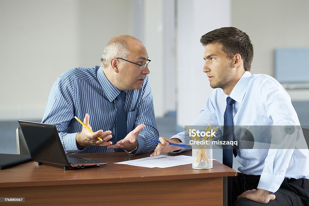 Deux Homme d'affaires avec ordinateur portable, bureau, prises - Photo de Bureau - Lieu de travail libre de droits