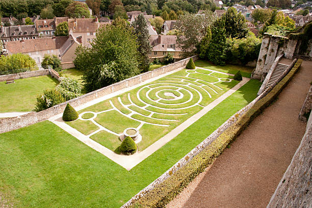 A labyrinth garden design set next to some buildings Labyrinth garden behind famous Chartres Cathedral chartres cathedral stock pictures, royalty-free photos & images