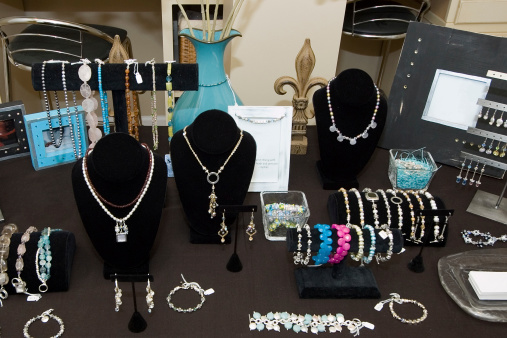 Display table in an upscale boutique. Table contains many custom products including jewelry, frames, and woodwork, and other accent pieces.