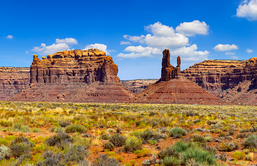 Buttes in Monument Valley, Arizona, under a partially clouded sky