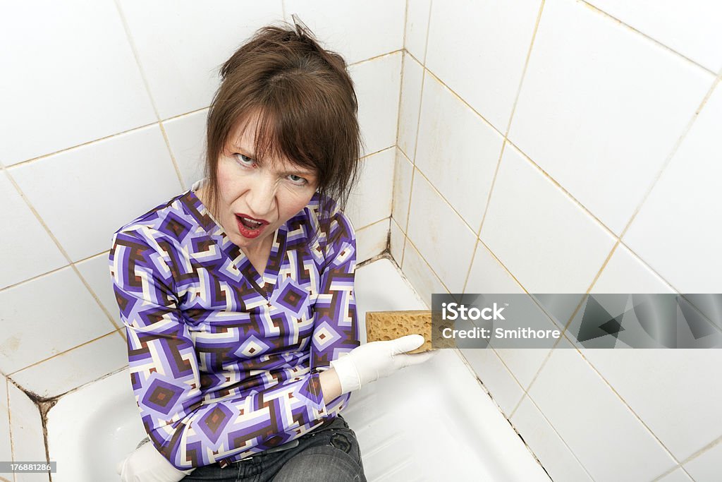 angry housewife unhappy woman washing bathroom shower with sponge Adult Stock Photo