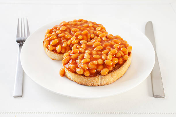 Beans on Toast "Bakes beans on thick sliced white toast with knife and fork. An easy,nourishing meal." Beans on Toast stock pictures, royalty-free photos & images