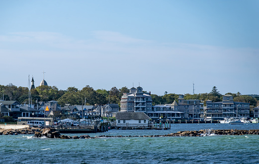 A typical New England scene of vacation homes and boats along a rocky inlet.