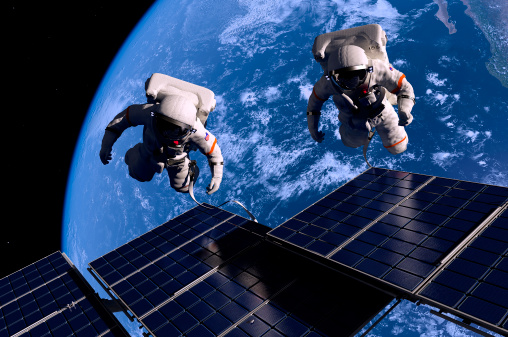 Spaceman holding a chroma key screen, standing against the Earth in an outer space