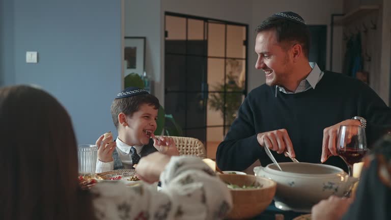 Happy little boy eating Rugelach during traditional Hanukkah dinner