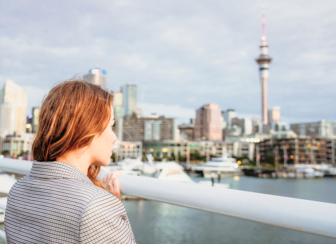 A woman looking across the water of Auckland's Viaduct Harbour