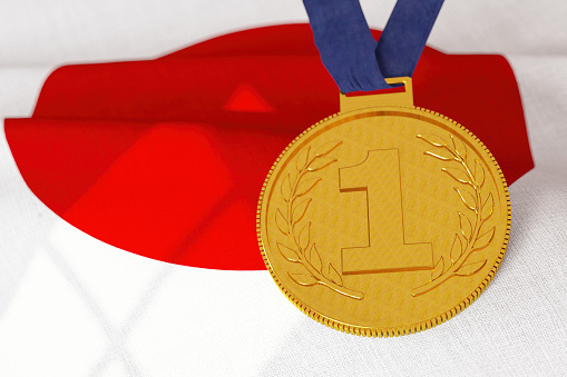 Gold medal with trophy cup and blue, red, white colors ribbon isolated on white background.