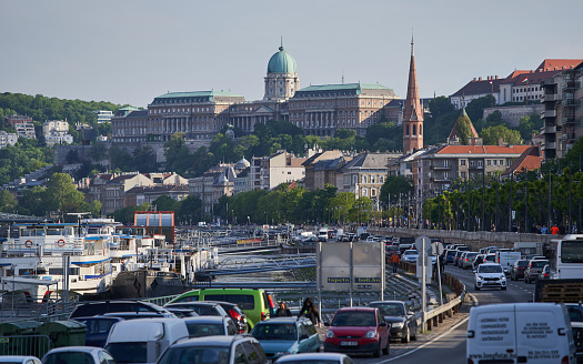 View on Royal Palace of Budapest (Hungarian: Budavári Palota) and busy city street. Budapest, Hungary - 7 May, 2019